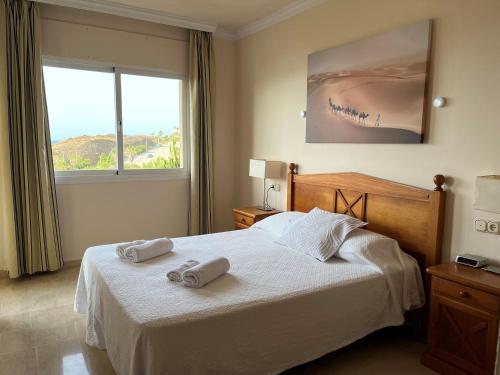 um quarto com uma cama com duas toalhas em Fantástico Apartamento con vistas al mar zona Club la Costa Castillo Fuengirola em Fuengirola