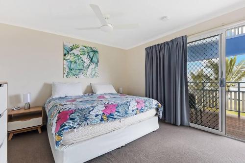 ein Schlafzimmer mit einem Bett und einem großen Fenster in der Unterkunft Villa 30 Tangalooma in Tangalooma