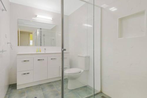 uma casa de banho com um WC e uma cabina de duche em vidro. em Villa 30 Tangalooma em Tangalooma