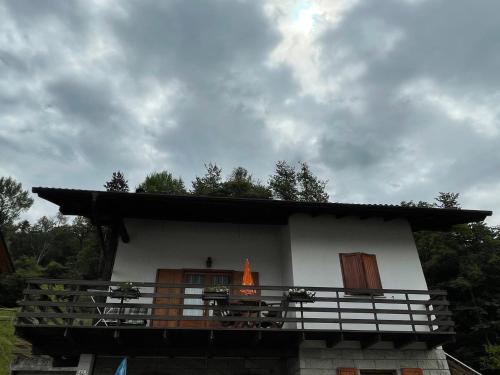 a small white house with an orange object on it at Villetta Casale in Comano Terme