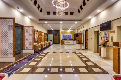 a lobby with a waiting room with chairs and a stage at Golden Tulip New Delhi - Hari Nagar in New Delhi