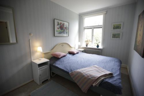 a bedroom with a bed with a blue blanket and a window at Kurrebo in Urshult