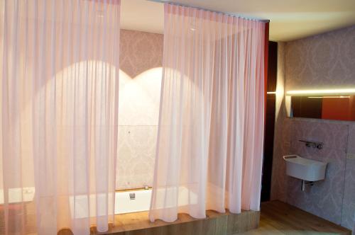 a bathroom with a shower curtain and a sink at Schopenhauer in Ghent