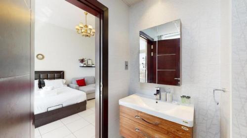 a bathroom with a sink and a bed and a mirror at Beautiful Studio Apartment Near New Dubai Mall I Balcony I Parking I Wifi I Furnished rooms in Dubai