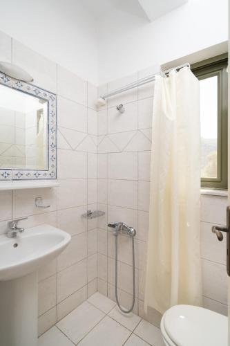 a bathroom with a shower curtain and a sink at Villa Luisa Exclusive Residences in Monemvasia
