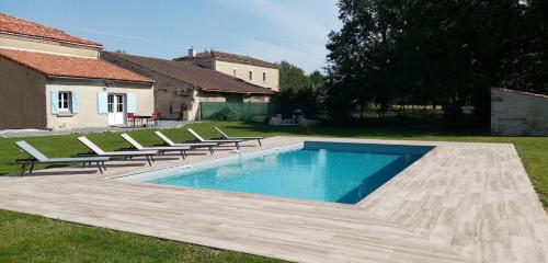 une piscine avec des chaises longues à côté d'une maison dans l'établissement La Chaudiette 1888, à Nantillé