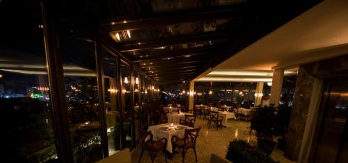 イスタンブールにあるCorinne Art & Boutique Hotelの夜の建物内のテーブルと椅子付きのレストラン
