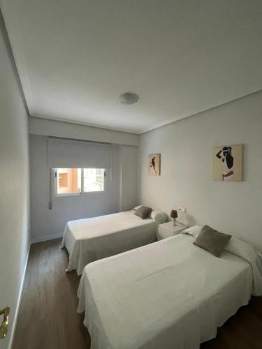 1 dormitorio con 2 camas y ventana en Jardines del Turia, en Valencia