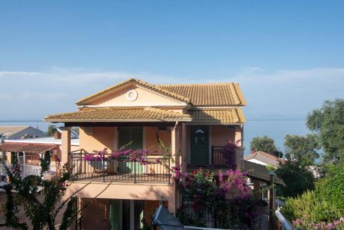 a house with a balcony and purple flowers at Villa Pepy Studio 2 in Mesongi