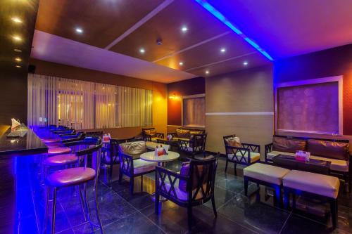 a restaurant with tables and chairs and purple lights at Golden Tulip New Delhi - Hari Nagar in New Delhi