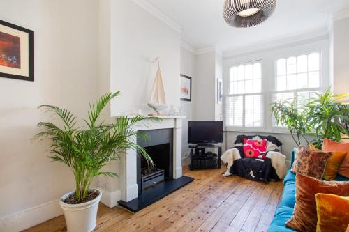 un soggiorno con divano blu e camino di ALTIDO 3-bedroom family home w/ garden a Londra