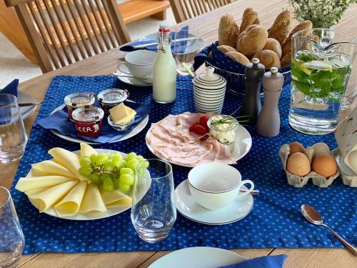 una mesa con platos de comida en un mantel azul en Tschardakenhof Appartements, en Lutzmannsburg