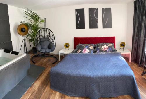 a bedroom with a blue bed and a bath tub at FiftyShades Apartmán s vířivkou in Jihlava