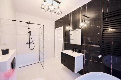 a bathroom with a shower and a sink and a mirror at Villa Agawa in Niechorze