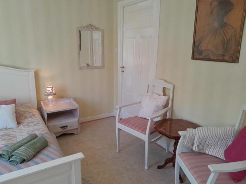 a bedroom with a bed and a chair and a table at Kurrebo in Urshult