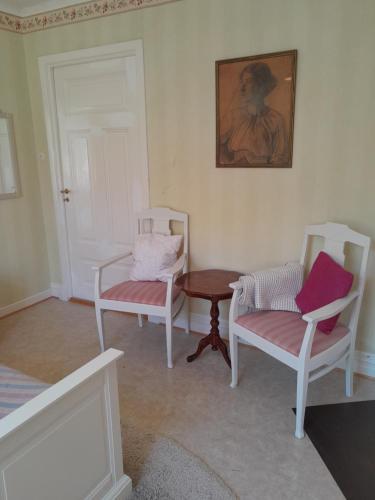 um quarto com duas cadeiras, uma mesa e um quadro em Kurrebo em Urshult