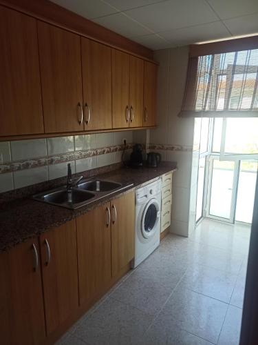 una cocina con fregadero y lavadora en La Rambleta, en L'Ametlla de Mar
