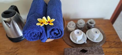 a blue towel with a yellow flower on a table at Adi House Homestay in Ubud