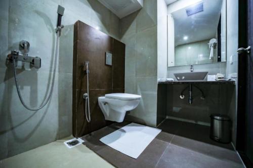 La salle de bains est pourvue d'une douche, de toilettes et d'un lavabo. dans l'établissement Cygnett Inn Sea View, à Digha