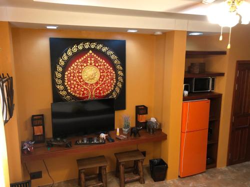 a living room with a tv and a table with chairs at On The Mekong Resort in Luang Prabang