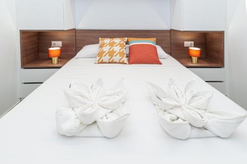 1 dormitorio con 1 cama blanca y 2 sillas blancas en Myflats Luxury Old Town en Alicante