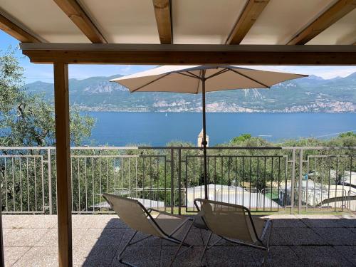 a patio with two chairs and an umbrella at Camping Le Maior in Brenzone sul Garda