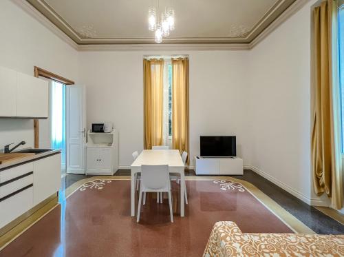 a living room with a table and a kitchen at Appartamenti in Villa del '900 (B) in Varazze