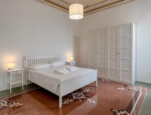 a white bedroom with a bed and two night stands at Appartamenti in Villa del '900 (B) in Varazze