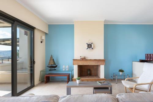 a living room with a couch and a fireplace at Aphaia Villa & Residences Aegina in Agia Marina Aegina