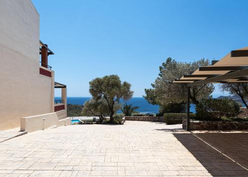 a patio of a house with a view of the ocean at Aphaia Villa & Residences Aegina in Agia Marina Aegina