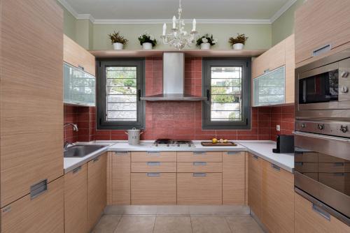 a kitchen with a sink and a stove top oven at Aphaia Villa & Residences Aegina in Agia Marina Aegina