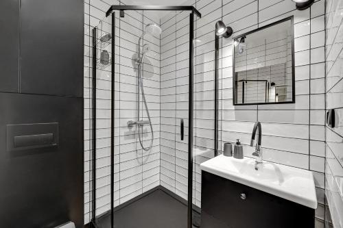 een badkamer met douche, wastafel en spiegel bij 4 Lions Grobla in Gdańsk