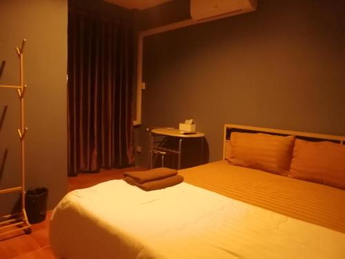 a bedroom with a bed and a table in it at airport house in Bangkok