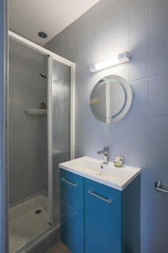 une salle de bain avec un lavabo bleu et une douche dans l'établissement Le gite de Kergrist, à Le Faouët