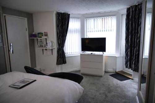 a hotel room with a bed and a flat screen tv at Bella Vista Lodge in Blackpool