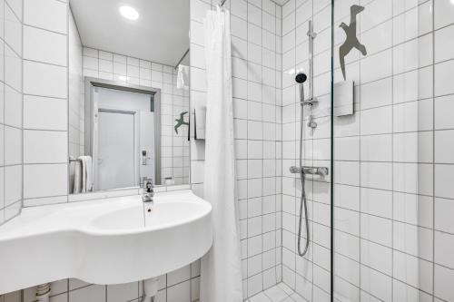 a white bathroom with a sink and a shower at Thon Partner Hotel Horten in Horten