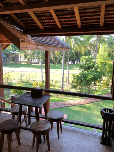a room with a table and chairs and a large window at On The Mekong Resort in Luang Prabang