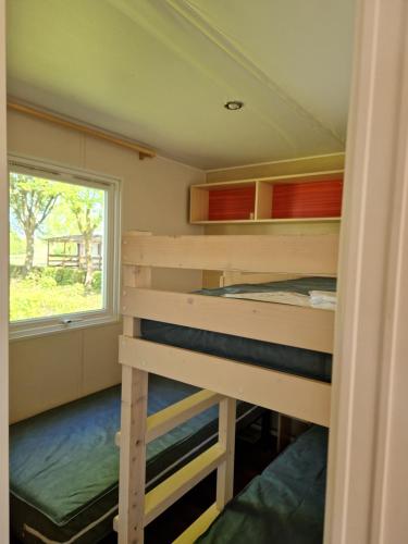 a bedroom with two bunk beds and a window at Camping le ried B021 et N038 in Boofzheim