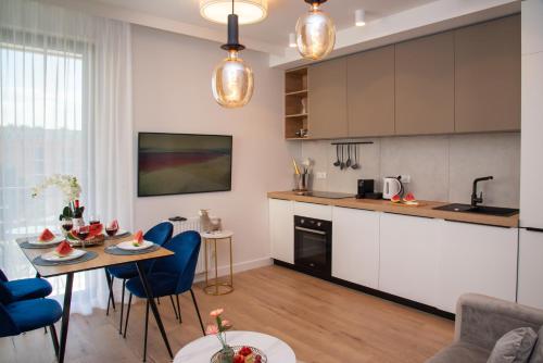 uma cozinha e sala de estar com mesa e cadeiras em Maya's Flats & Resorts 30 - 3 rooms flat in Garden Gate Gdansk em Gdansk