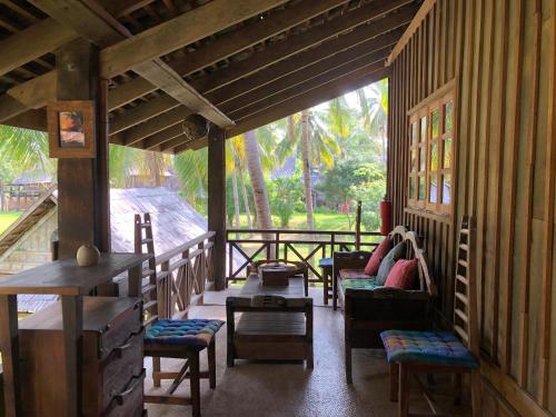 a porch of a house with chairs and tables at On The Mekong Resort in Luang Prabang