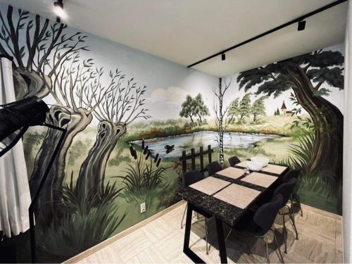 a dining room with a painting of trees and a table at Guesthouse Ter Linden in Bazel