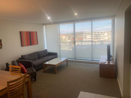 a living room with a couch and a large window at 40 William Street Apartments in Port Macquarie