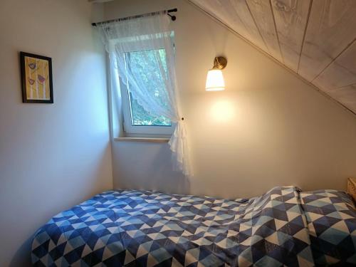 a bedroom with a bed and a window at Smocze Ranczo 2 in Ośno Lubuskie