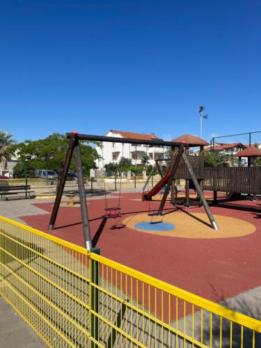 a playground with a swing set in a park at Apartments Miriam Srima in Vodice