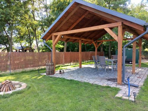 a pavilion with a table and chairs in a yard at Smocze Ranczo 2 in Ośno Lubuskie