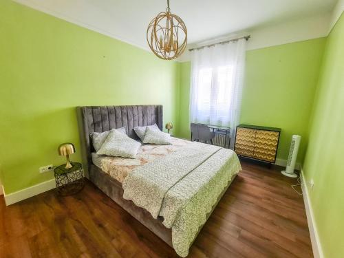 - une chambre avec un lit aux murs verts et un lustre dans l'établissement Appartement Nice à proximité de la plage, à Nice