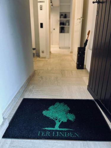 a rug with a tree on the floor in a hallway at Guesthouse Ter Linden in Bazel