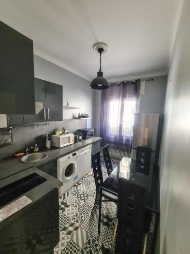 La cuisine est équipée d'une table, d'un évier et d'un four micro-ondes. dans l'établissement Appartement Nice à proximité de la plage, à Nice