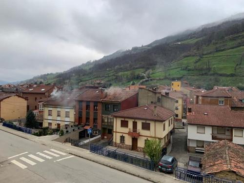 a city with houses and a mountain in the background at Apartamento Fele con garaje in Felechosa