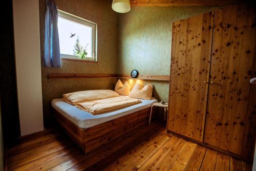 a small bedroom with a bed in a room with a window at Chalet Hebalm in Pack